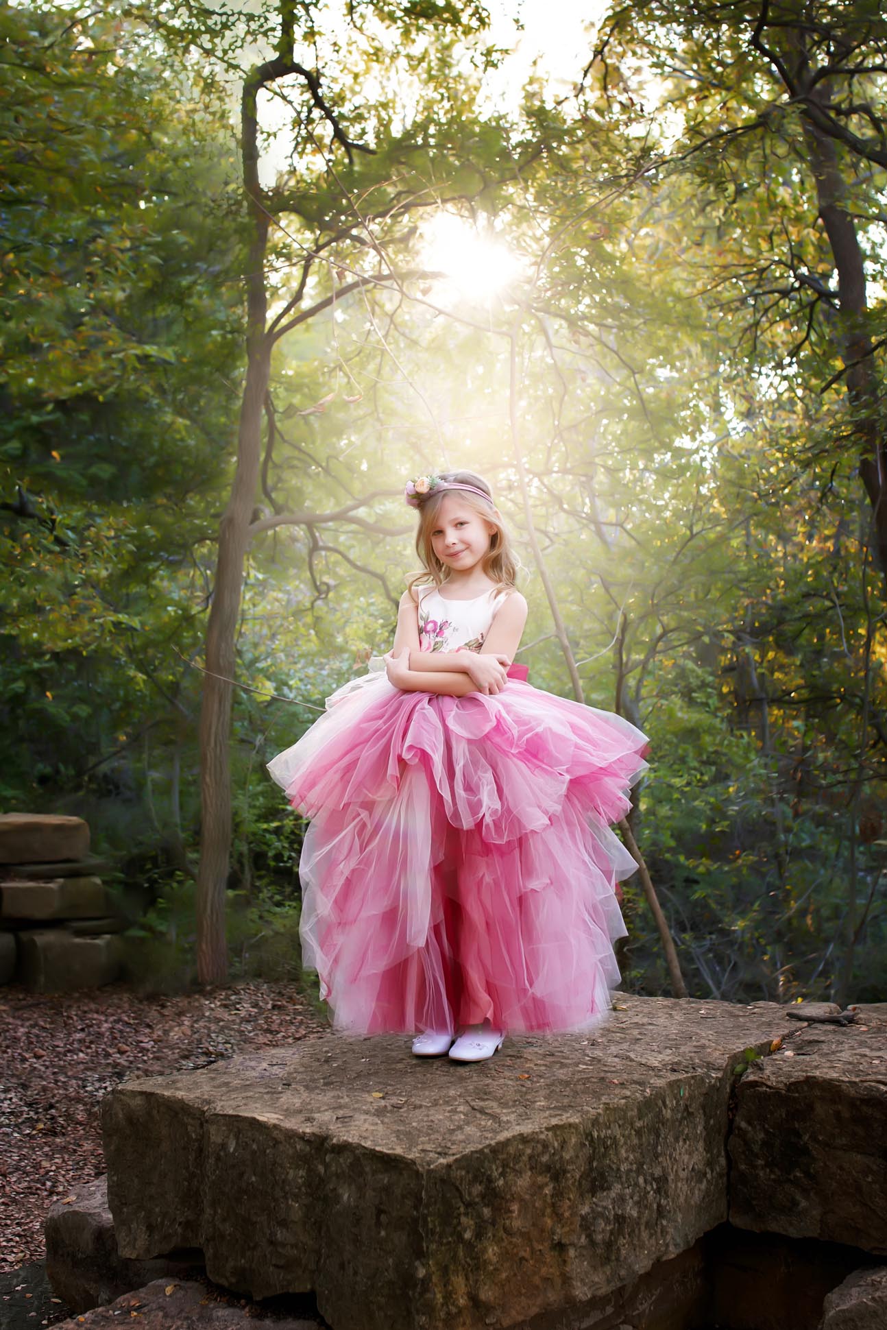 Dallas child photographer shares portrait of girl wearing pink tulle dress standing in a forest.