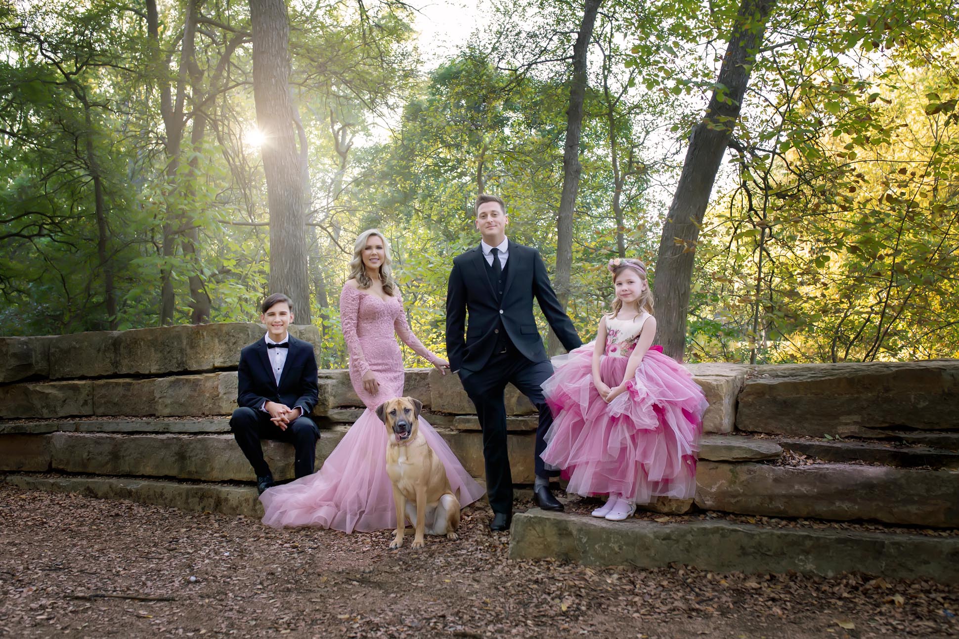 Dallas family photographer shares portrait of family in wooded area at Prairie Creek Park in Richardson Texas dressed in formal wear