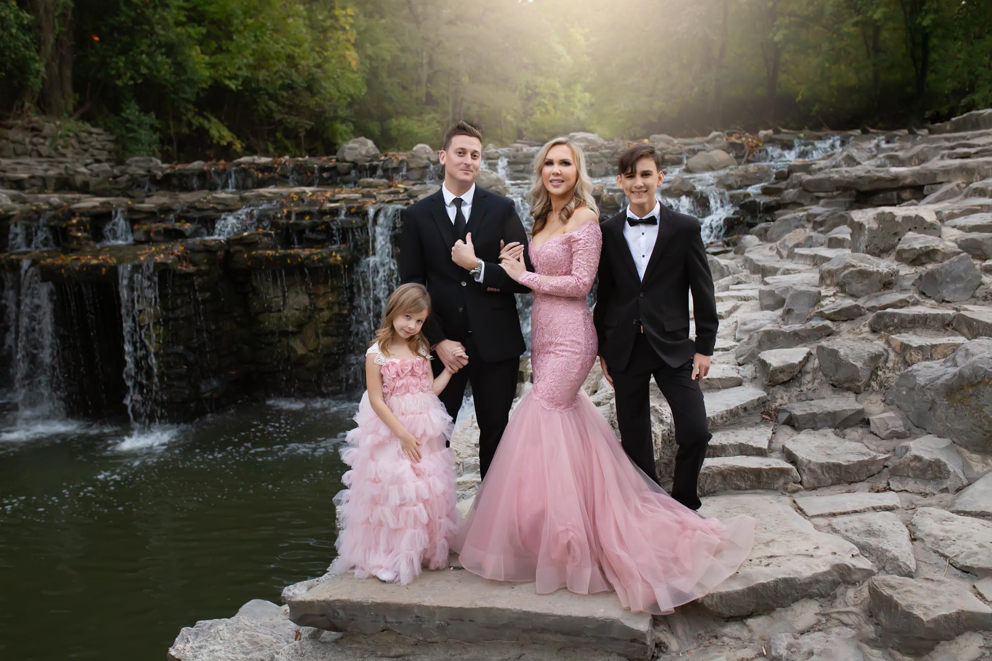 Dallas family photographer shares portrait of family in front of waterfall at Prairie Creek Park in Richardson Texas