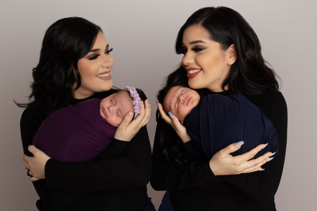 Identical twins had babies one day apart pictured here holding their babies photographed by Laura Levitan of Mod L Photography a Dallas studio