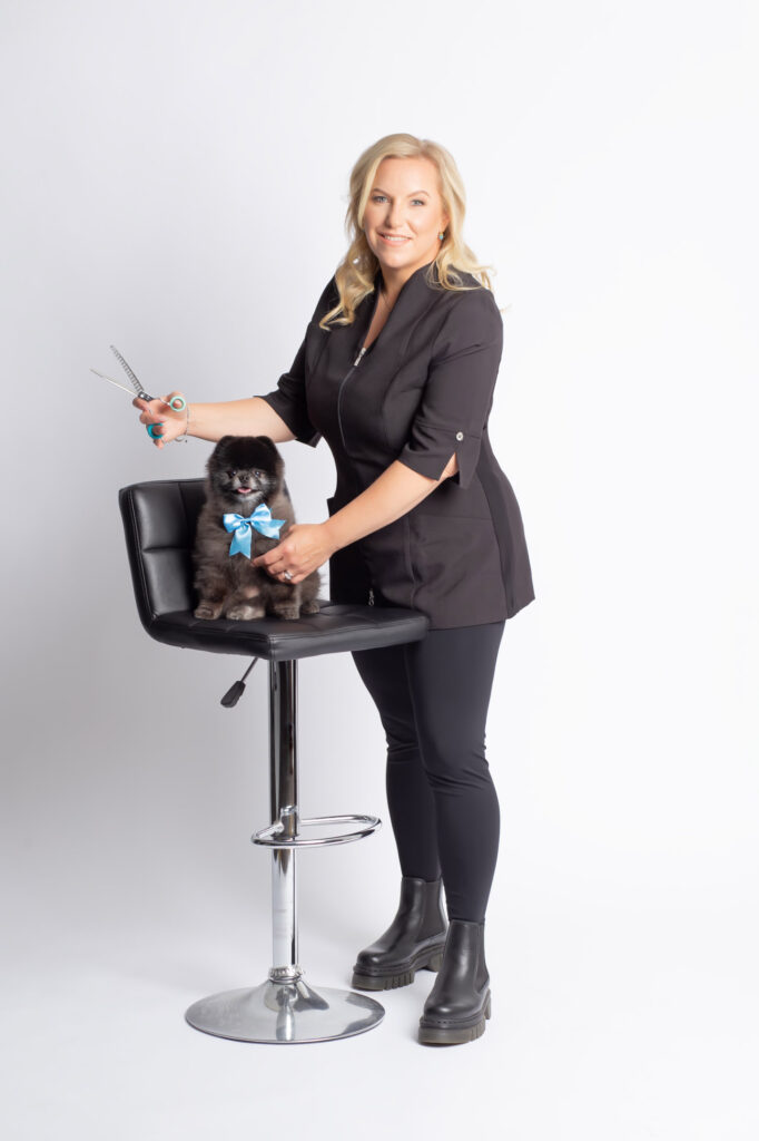 A Luxury mobile dog groomer Luxe Paws Mobile Pet Spa owner Rhea Vanderwerf pictured with her black Pomeranian posed on a salon chair while she prepares to groom him Dallas pet photographer Laura Levitan of Mod L Photography Captured this portrait